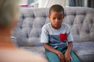 A young boy sitting on top of a couch.