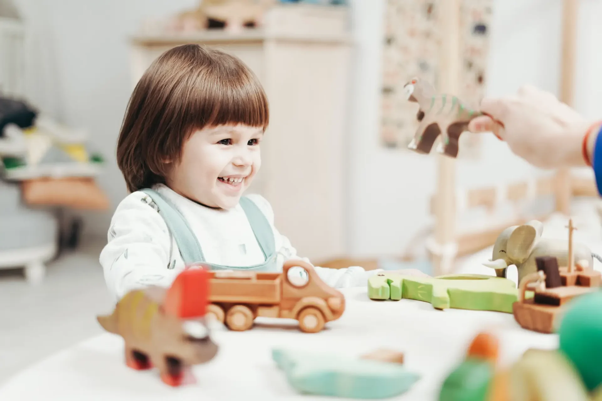 A child playing with wooden toys in a room.