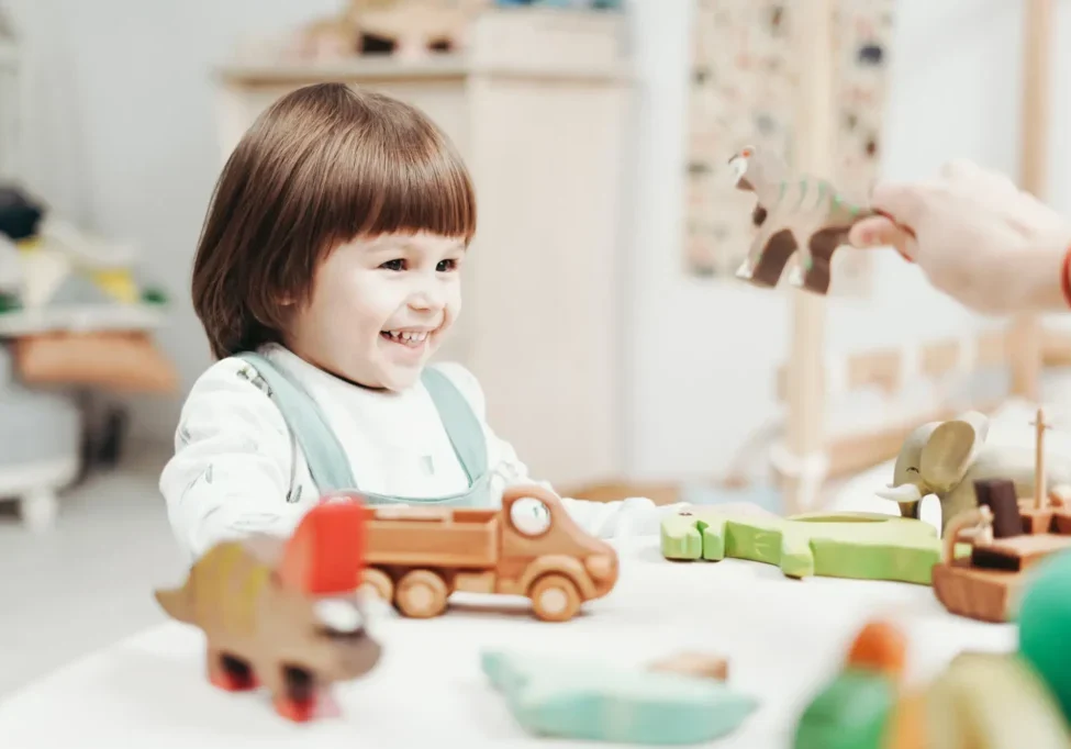 A child playing with wooden toys in a room.